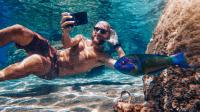 Funny man selfie with mobile phone underwater at sea: internet addiction.