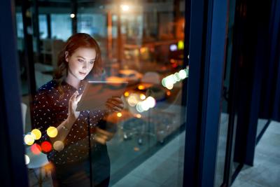 Cropped shot of a young businesswoman working late on a digital tablet in an office