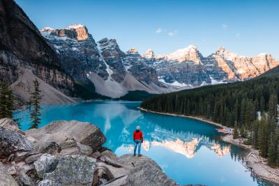 Man looking at Moraine lake at sunrise, Banff National Park, Alberta, Canada