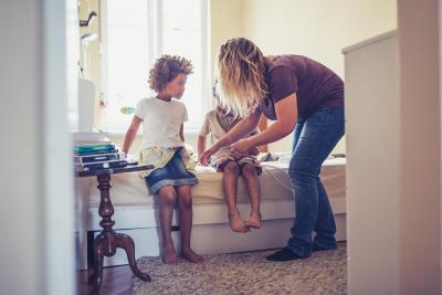 Mother preparing kids for school. Mixed race family with two child