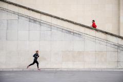 Caucasian runners jogging near staircase