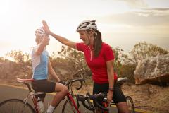 Professional female cyclists on road bikes at sunset